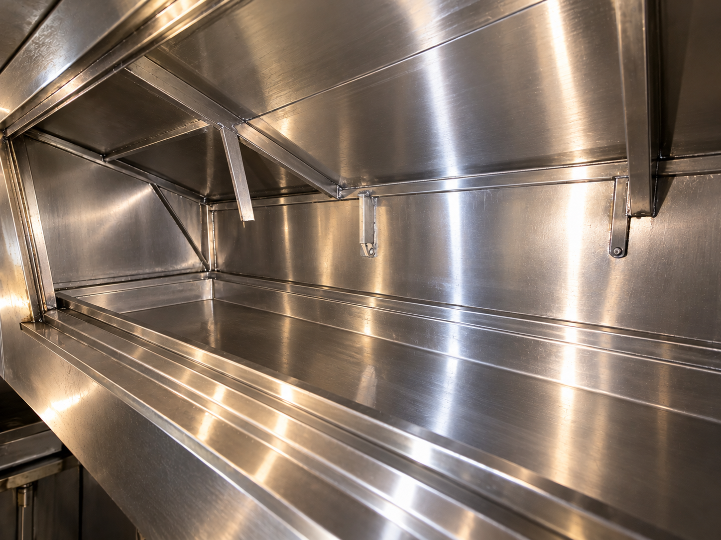 Commercial kitchen exhaust hood interior cleaned to bare metal